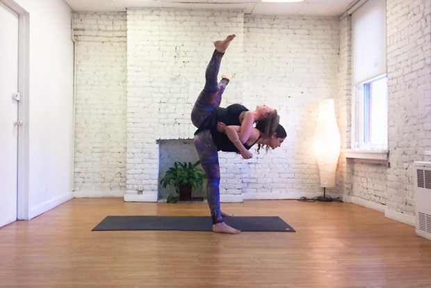 5 Beginner AcroYoga Poses That Are Totally Doable: Partner Forward Fold Pose